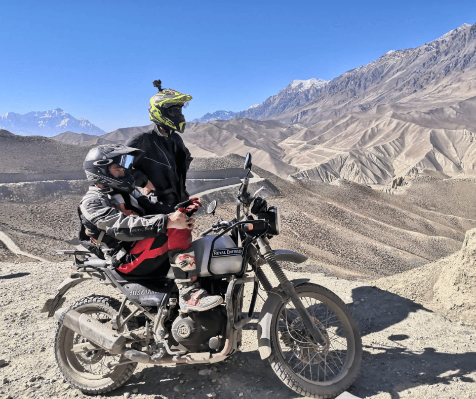 A thrilling motorbike expedition through Upper Mustang, Nepal, featuring riders on Royal Enfield Himalayan bikes against a backdrop of rugged Himalayan landscapes.