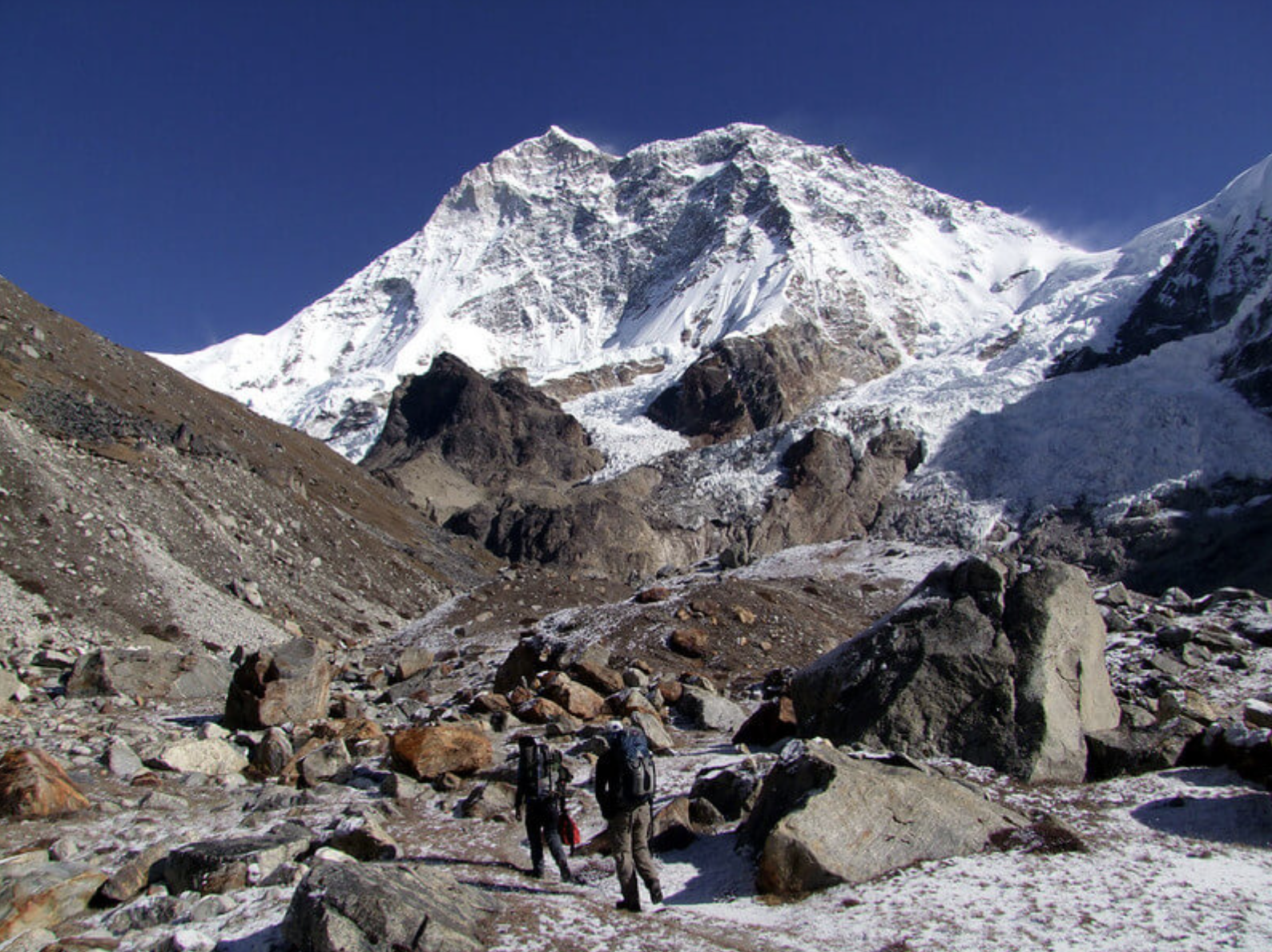 a group of people standing on top of a snow covered mountain