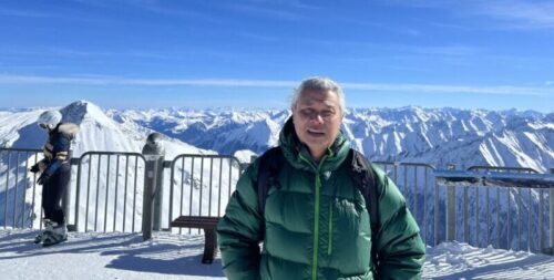 Raj Tamang standing on top of a snow covered peak in the Alps.