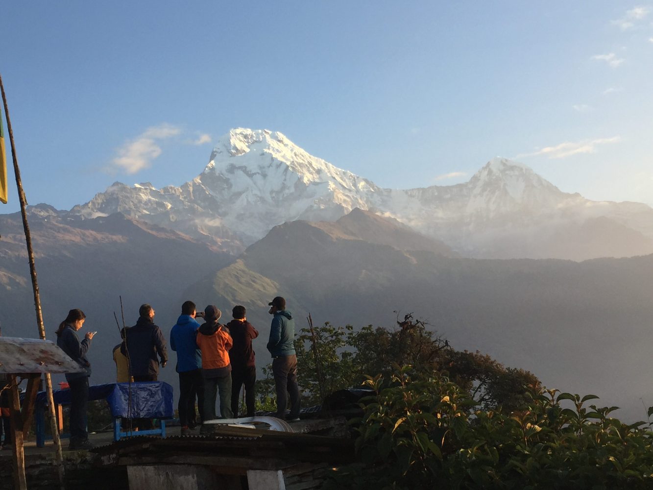 a group of people standing in front of a mountain